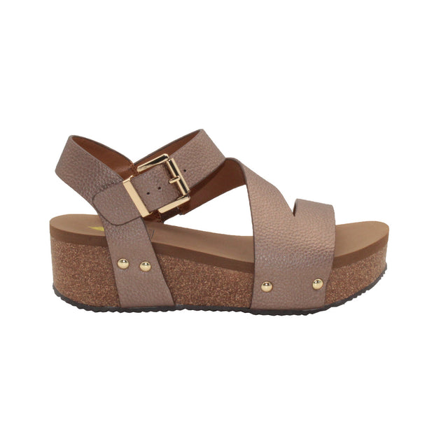 Vegan leather or heavy canvas asymmetrical upper Synthetic lining Adjustable metal buckle and metal clog studs Asymmetrical sandal with back strap Ultra comfort EVA insole Cork wedge Rubber traction outsole Approx. 2” heel height bronze side