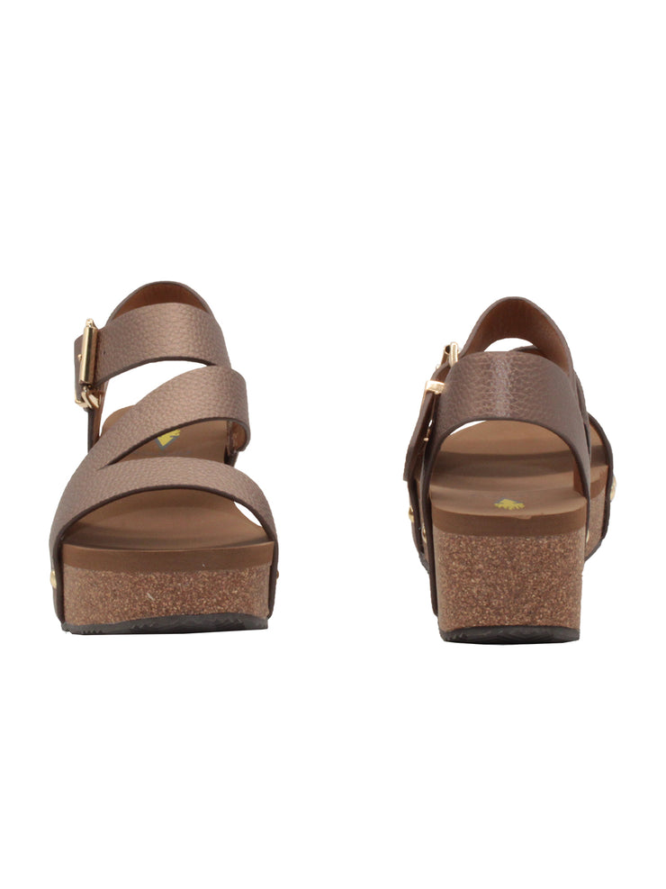 Vegan leather or heavy canvas asymmetrical upper Synthetic lining Adjustable metal buckle and metal clog studs Asymmetrical sandal with back strap Ultra comfort EVA insole Cork wedge Rubber traction outsole Approx. 2” heel height bronze front and back