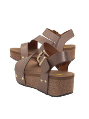 Vegan leather or heavy canvas asymmetrical upper Synthetic lining Adjustable metal buckle and metal clog studs Asymmetrical sandal with back strap Ultra comfort EVA insole Cork wedge Rubber traction outsole Approx. 2” heel height bronze back