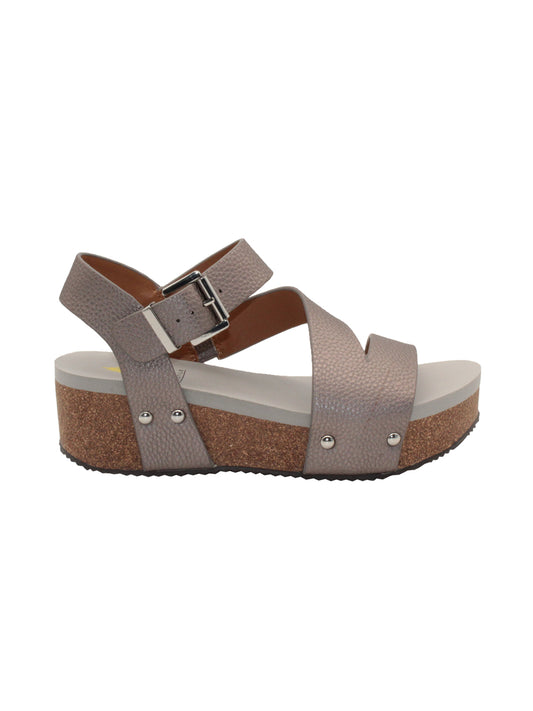 Vegan leather or heavy canvas asymmetrical upper Synthetic lining Adjustable metal buckle and metal clog studs Asymmetrical sandal with back strap Ultra comfort EVA insole Cork wedge Rubber traction outsole Approx. 2” heel height pewter side