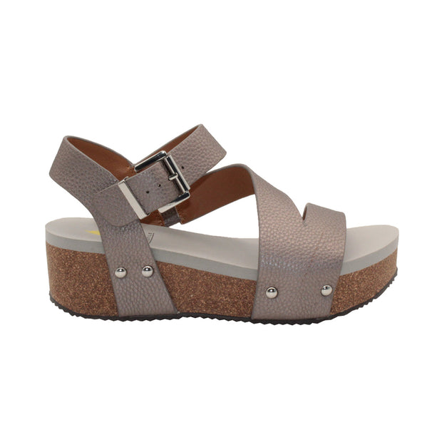 Vegan leather or heavy canvas asymmetrical upper Synthetic lining Adjustable metal buckle and metal clog studs Asymmetrical sandal with back strap Ultra comfort EVA insole Cork wedge Rubber traction outsole Approx. 2” heel height pewter side