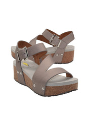 Vegan leather or heavy canvas asymmetrical upper Synthetic lining Adjustable metal buckle and metal clog studs Asymmetrical sandal with back strap Ultra comfort EVA insole Cork wedge Rubber traction outsole Approx. 2” heel height pewter  