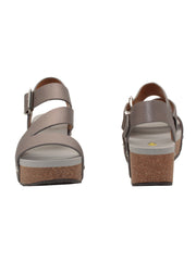 Vegan leather or heavy canvas asymmetrical upper Synthetic lining Adjustable metal buckle and metal clog studs Asymmetrical sandal with back strap Ultra comfort EVA insole Cork wedge Rubber traction outsole Approx. 2” heel height pewter  front and back