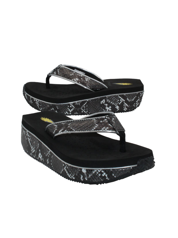 Faux snakeskin upper Soft webbed textile thong post Padded textile lining for comfort Slip-on thong wedge style Ultra-comfort EVA insole Round toe and squared off heel shape Rubber traction outsole Approx. 1.5” wedge heel height