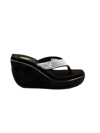 Volatile’s Glimpse platform wedge sandal’s leather upper straps are embellished with sparkling rhinestones. The classic thong style has a soft fabric post that rests gently between your toes, and the signature ultra-comfort EVA insole provides all day comfort. Perfect for special occasions, they’ll complement everything from dresses to jeans. black