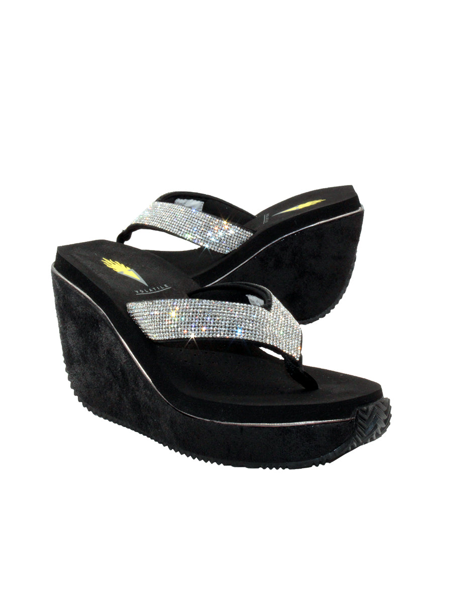 Volatile’s Glimpse platform wedge sandal’s leather upper straps are embellished with sparkling rhinestones. The classic thong style has a soft fabric post that rests gently between your toes, and the signature ultra-comfort EVA insole provides all day comfort. Perfect for special occasions, they’ll complement everything from dresses to jeans. black 2