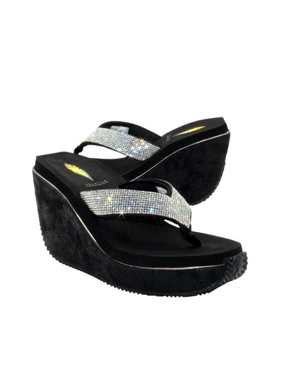 Volatile’s Glimpse platform wedge sandal’s leather upper straps are embellished with sparkling rhinestones. The classic thong style has a soft fabric post that rests gently between your toes, and the signature ultra-comfort EVA insole provides all day comfort. Perfect for special occasions, they’ll complement everything from dresses to jeans. black 2