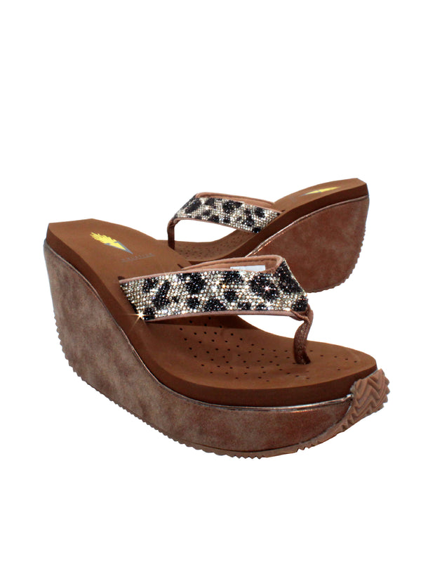 Volatile’s Glimpse platform wedge sandal’s leather upper straps are embellished with sparkling rhinestones. The classic thong style has a soft fabric post that rests gently between your toes, and the signature ultra-comfort EVA insole provides all day comfort. Perfect for special occasions, they’ll complement everything from dresses to jeans. tan multi 2