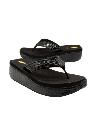 The Mini Croco thong wedge sandal by Volatile is crafted from a luxe, glossy faux crocodile material and gives a modest lift in height with the comfortable 1 1/2” wedge. They feature Volatile’s signature ultra comfort EVA insole for all day comfort, padded textile lining that rests gently on the skin, and nonskid rubber traction outsoles to keep feet grounded on all surfaces.  black 2